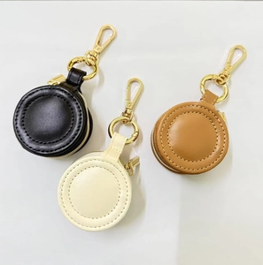Detail of round mini jewelry storage cases with gold zippers and spring clip hooks