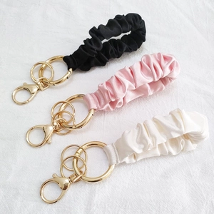 Satin scrunchie wristlet keychain in black, pink, and beige with gold metal lobster clasp