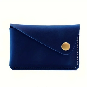 Slim navy blue leather card holder with gold snap fastener and hand-stitched detailing