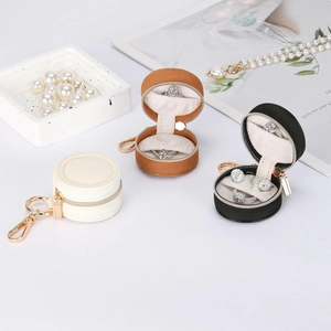 Portable mini round jewelry organizer in beige, brown, and black with gold keychain