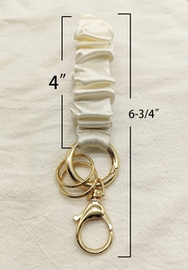 Cream satin ruched wristlet keychain with gold clasp showing 6.75 inch total length