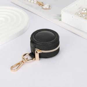Detail of round black PU leather mini jewelry case with gold zipper and lobster clasp