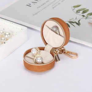 Detailed interior of a mini round jewelry travel case with ring slots and soft lining