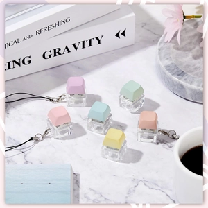 Set of 6 macaron-colored mechanical keyboard fidget keychains on marble desk background