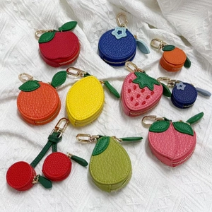 Close-up of fruit-shaped PU leather coin purses with litchi texture and gold metal hooks