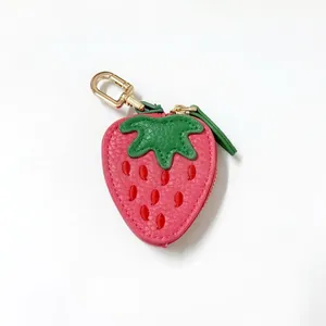 Detail of pink strawberry coin purse with green leaves and gold zipper hardware