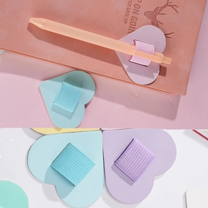 Detail of heart-shaped PU leather self-adhesive pen holders for notebooks in pastel colors