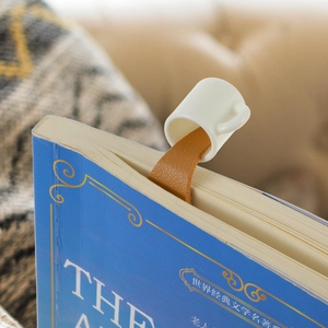 Detailed view of creative spilled coffee bookmark in leather on a blue book page