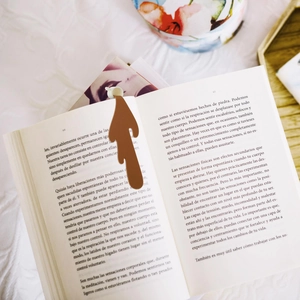 Macro shot of creative spilled coffee bookmark in dark brown silicone on book pages