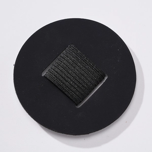 Close-up of a circular PU leather pen holder with a black elastic loop for notebooks