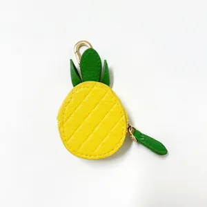 Macro shot of pineapple leather coin purse with quilted detail and green leaf charm