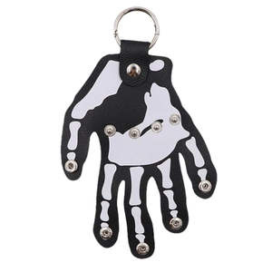 Detail of hand skeleton leather keychain with white bone print and silver metal rivets