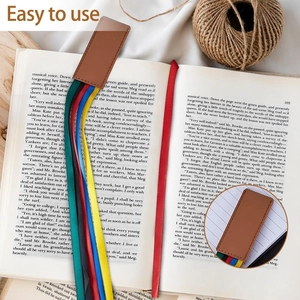 Segnalibro in ecopelle con cinque nastri colorati inserito in un libro aperto