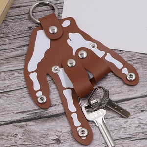 Unique brown leather bone-shaped keychain with white skeleton print and metal key rings