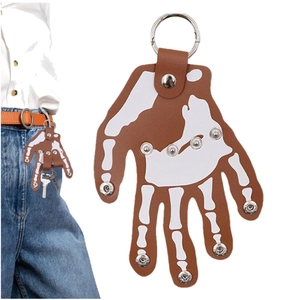 Punk style skull leather hand keychain with metal rivets attached to blue jeans loop