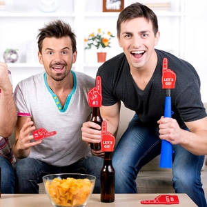Close-up of mini red foam fingers with cheering slogans on beer bottles in a party setting
