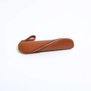 Detailed view of brown PU leather pencil case with triangle structure and metal zipper