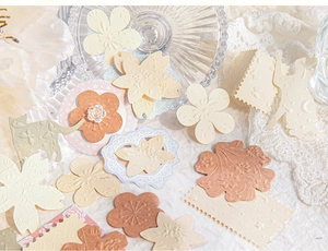Close-up of vintage scrapbook paper set with floral embossed textures and lace
