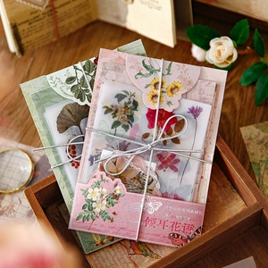 Vintage floral scrapbooking paper set with botanical designs on dark wooden tray