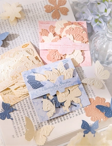 Detailed close-up of embossed flower and butterfly textured paper for DIY scrapbooking