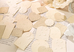 Close-up of vintage embossed paper scraps featuring floral and butterfly relief patterns