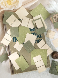 Detail of vintage stamp-shaped paper materials with embossed floral patterns for scrapbooking