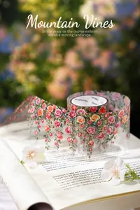 Detailweergave van decoratieve PET-tape met rozen- en rankmotieven op een boek
