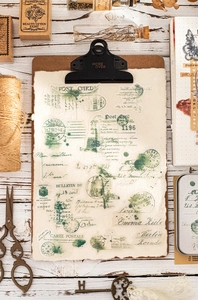 Close-up of vintage PET stickers with dark green botanical motifs and antique stamps