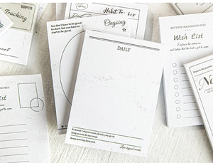 Macro shot of minimalist paper memo pad with daily habit tracker and wish list pages
