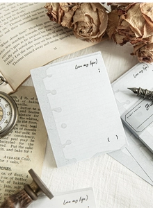 Macro view of vintage blank notepad sheets with aesthetic handwriting and floral props