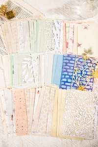 Dettaglio di carta scrapbooking vintage con trame floreali e motivi tagliati al laser