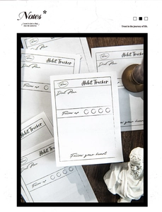 Macro view of vintage style habit tracker note cards on a rustic wooden desk surface