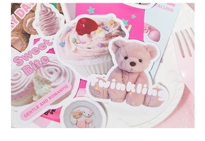Detail of sweet DIY scrapbook kit featuring cute bears and Kitty motifs on a ceramic plate