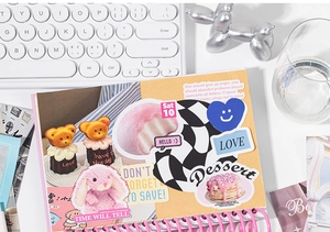 Close-up of pink spiral notebook with cute DIY stickers and decorative scrapbook elements