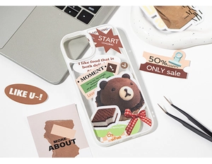 Detail of DIY collage phone case featuring 3D brown bear and vintage stickers