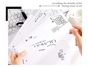 Vue à plat de cartes de collage décoratives minimalistes noir et blanc sur bureau blanc