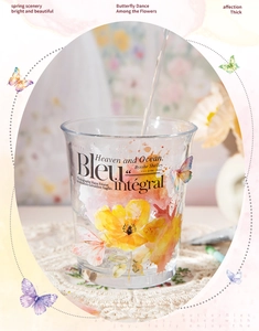 Vaso de cristal con flores y mariposas acuarela sobre un posavasos de encaje