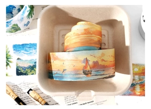 Macro shot of sunset sea themed washi tape with watercolor landscapes for DIY scrapbooking