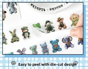 Close-up of die-cut washi tape featuring cartoon animals being peeled with tweezers