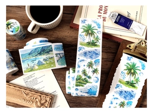 Macro detail of watercolor ocean theme washi tape on a wooden desk with artistic props