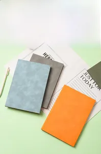 Detail of A5 soft faux leather notebooks in light blue, gray, orange and dark green covers