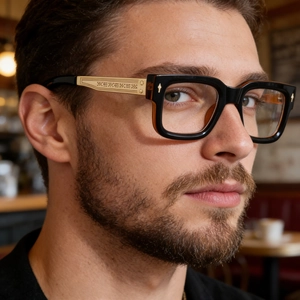 Close-up of retro square frames with amber gradient and engraved gold metal temples