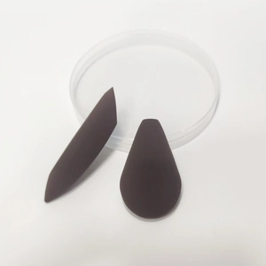 Macro detail of two brown teardrop beauty sponges with matte texture on white background