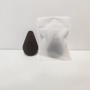 Detailed macro view of dark brown teardrop beauty blender with frosted storage bag
