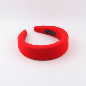 Detail view of the red padded headband featuring a woven Hand Made label on the inner side