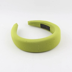 Detail of green padded headband with knit texture and Hand Made woven label