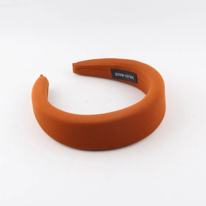 Detail view of handmade orange sponge headband showing the interior handmade label