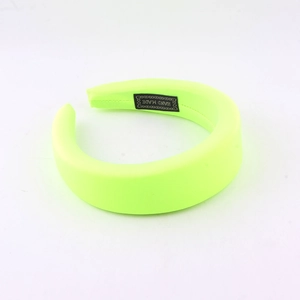 Detailed shot of fluorescent sponge headband showing the handmade label and fabric texture