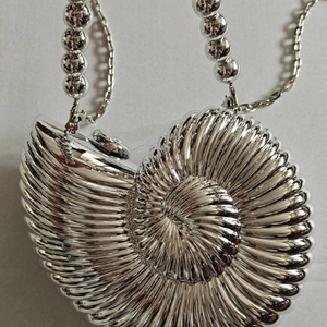 Silver nautilus shell evening clutch with metallic ridges and bead chain strap