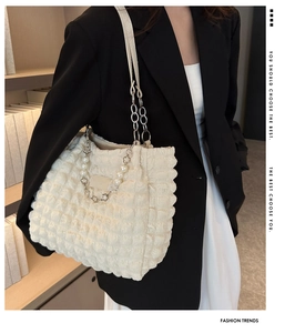 Détail du sac à bandoulière gaufré avec chaîne en perles et breloques florales